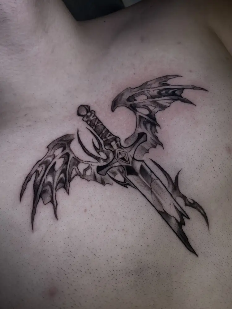 Tatuagem blackwork de espada alada no peito, por Luan Machado, Clash Tattoo Ribeirão Preto