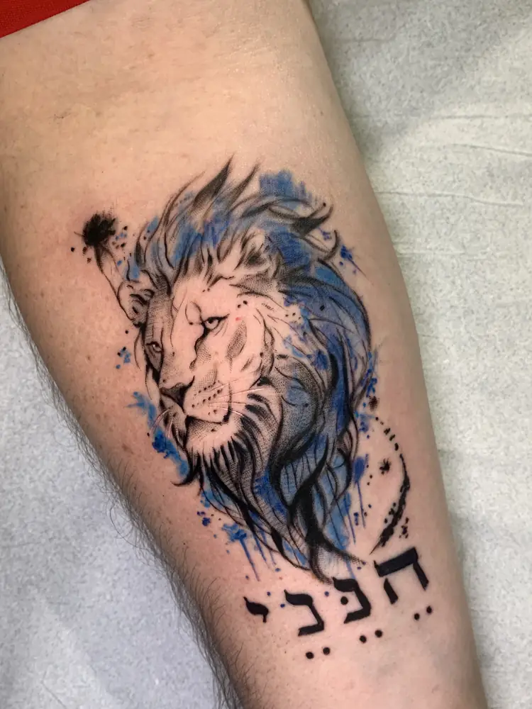 Tatuagem de leão em aquarela com lettering no antebraço, por Rafa, Clash Tattoo Ribeirão Preto