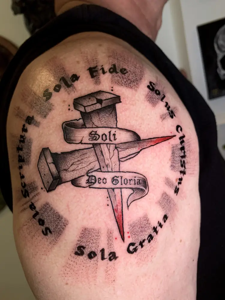 Tatuagem blackwork de cruz com lettering no ombro, por Rafa, Clash Tattoo Ribeirão Preto