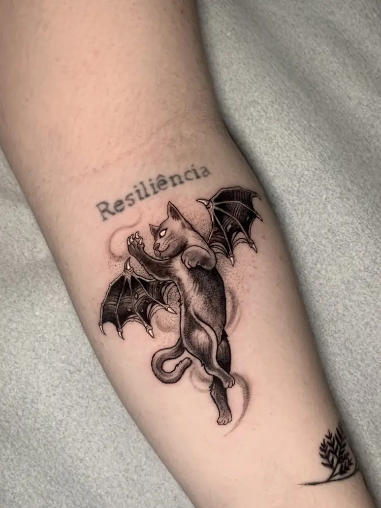 Tatuagem blackwork de gato alado no antebraço, por Rafa, Clash Tattoo Ribeirão Preto