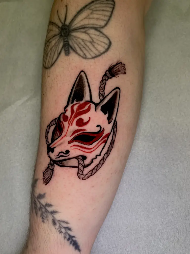 Tatuagem de máscara kitsune com vermelho no antebraço, por Rafa, Clash Tattoo Ribeirão Preto